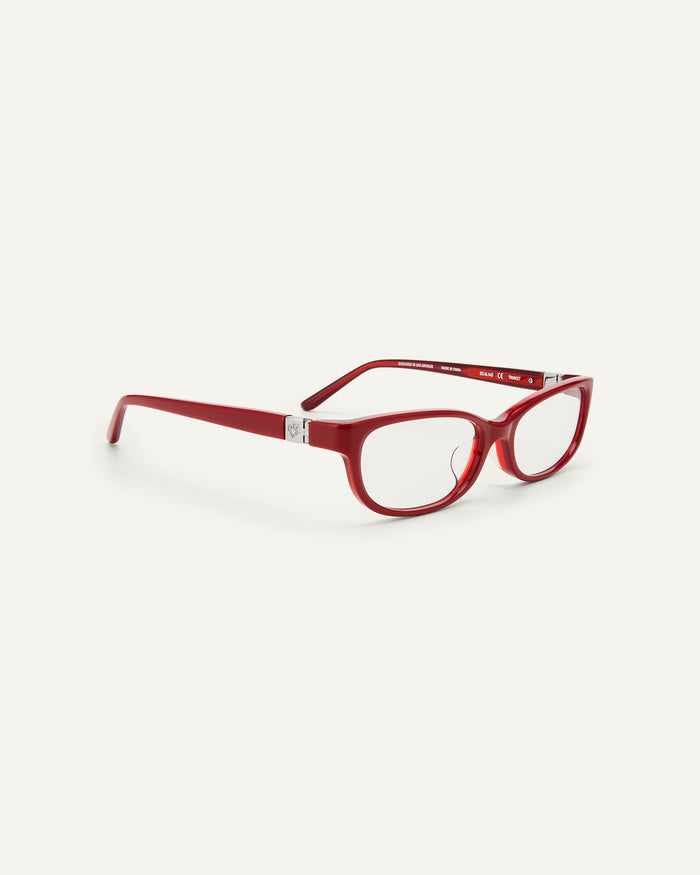 Quarter shot of Bonnie Clyde Trinket sunglasses in layered red with clear lenses.