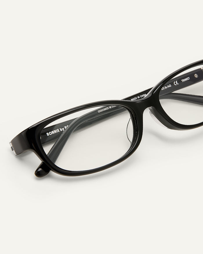 Side shot of Bonnie Clyde Trinket sunglasses in black with clear lenses.