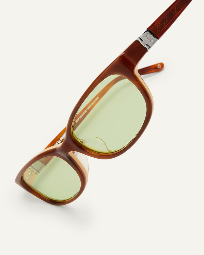 Side shot of Bonnie Clyde Trinket sunglasses in layered brown tortoise with green lenses.