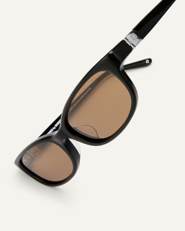 Side shot of Bonnie Clyde Trinket sunglasses in black with brown lenses.