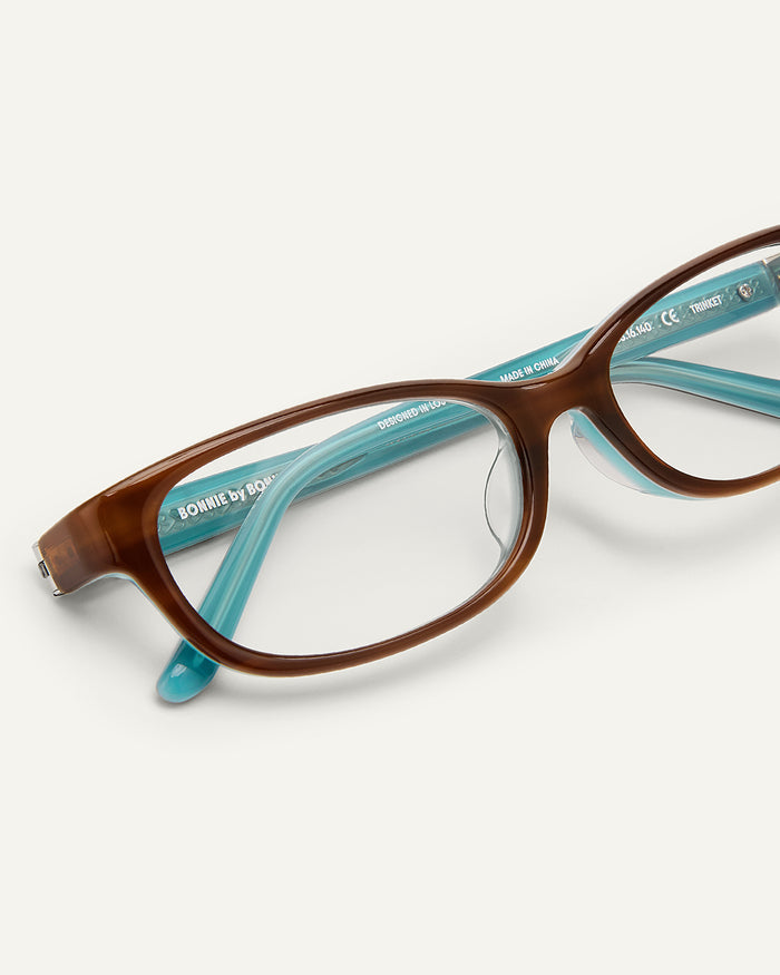 Side shot of Bonnie Clyde Trinket sunglasses in layered teal demi with clear lenses.