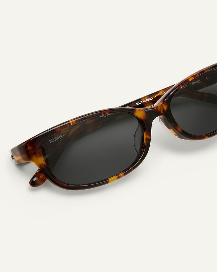 Side shot of Bonnie Clyde Trinket sunglasses in tortoise with black lenses.