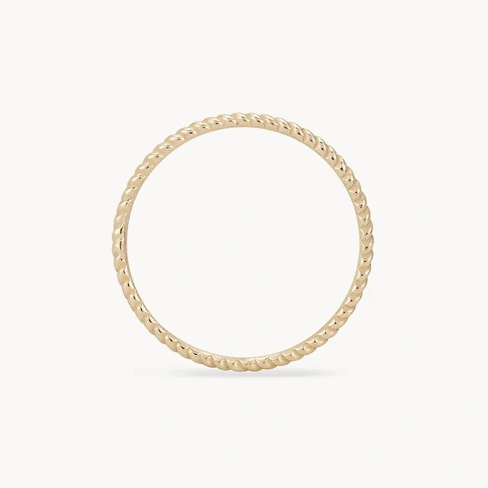 A delicate, thin gold ring with a subtle twisted rope design, displayed against a plain white background. The twisted stacking ring - 10k yellow gold from bluboho is perfectly round and features detailed craftsmanship with uniform twists.