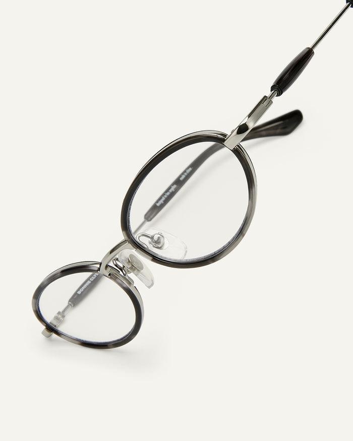 Close-up shot of Bonnie Clyde Voodoo optical frames in silver and black tortoise with clear lenses.