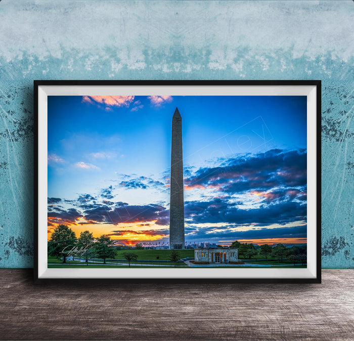 a photograph of the Washington Monument at sunset, with the sky filled with vibrant colors and clouds.