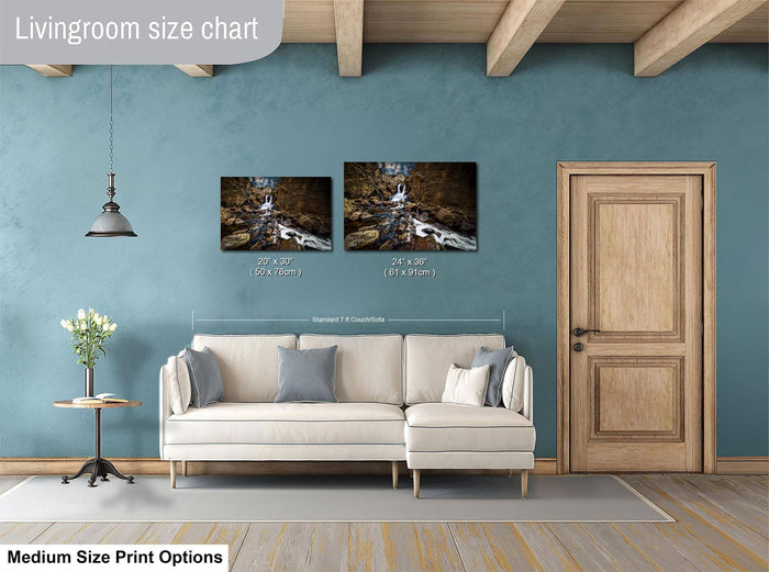a living room with a white sofa, a wooden door, and a painting hanging on the wall. The painting is of a waterfall, and the sofa is positioned in front of it. The living room appears to be well-lit and decorated with a wooden floor and a hanging light fixture.