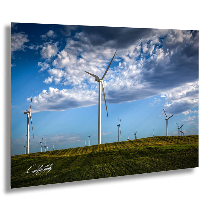 A field of wind turbines against a blue sky with clouds, creating a picturesque landscape.