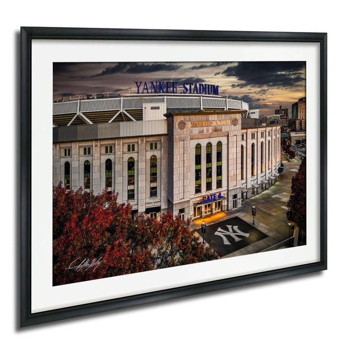 A framed photograph of Yankee Stadium, a baseball stadium located in New York City, with the iconic New York Yankees logo prominently displayed on the front of the building.