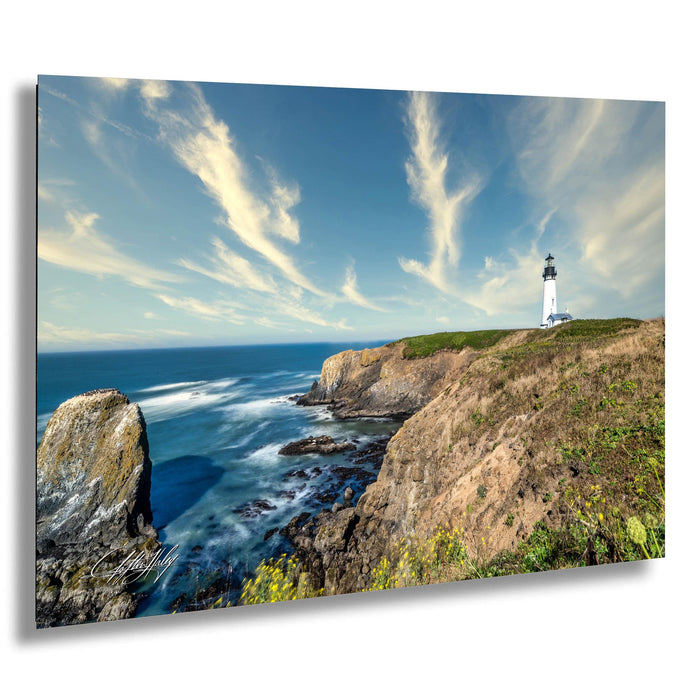 A picturesque coastal scene with a lighthouse standing on a cliff overlooking the ocean. The sky is blue with wispy clouds, and the rocky coastline is covered in lush vegetation. The image is a collage of multiple images, and the phrase "The image depicts" is not used.