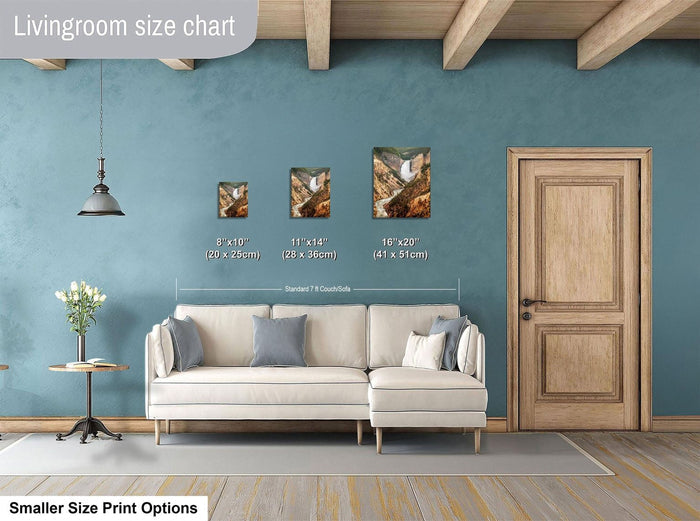 a living room with a white sofa, a wooden door, and a hanging light fixture. There are three framed pictures of landscapes displayed on the wall, each with a different size and height. The wall is painted in a light blue color, and the floor is covered with a gray rug.
