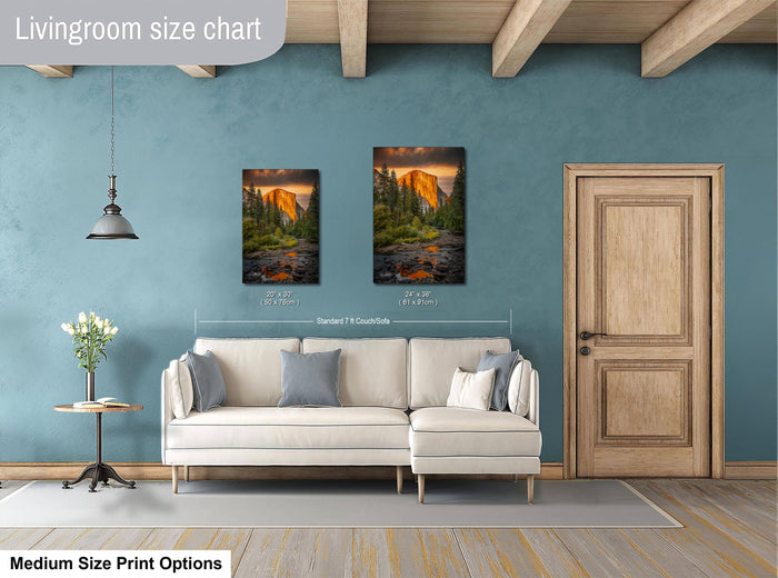 a living room with a white sofa, a wooden door, and two framed landscape paintings hanging on the wall.