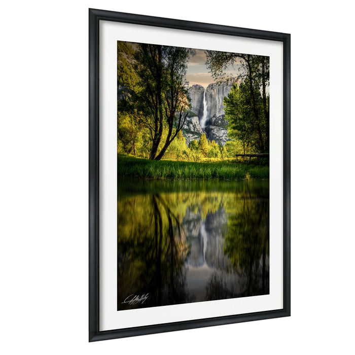 a serene landscape with a waterfall cascading down a rocky cliff, surrounded by lush greenery and reflected in a calm body of water.
