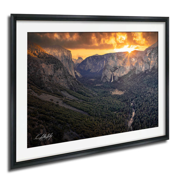 a breathtaking view of a mountainous landscape at sunset, with the sun setting behind the mountains and casting a warm, golden glow over the scene.