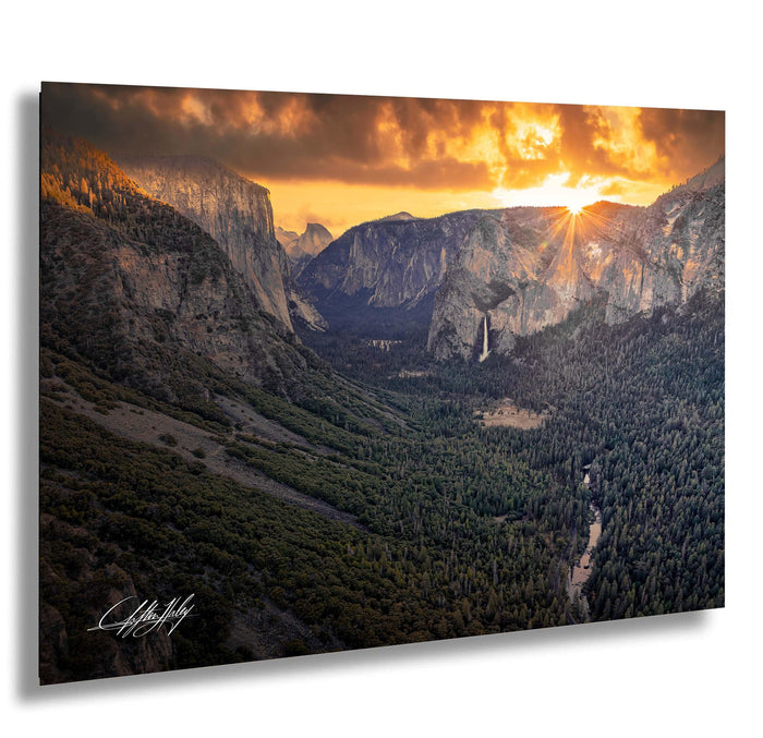 a breathtaking view of a mountainous landscape at sunset, with the sun setting behind the mountains and casting a warm, golden glow over the scene.