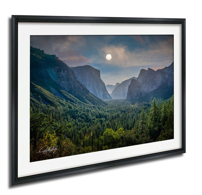 a breathtaking mountainous landscape with a full moon illuminating the scene.