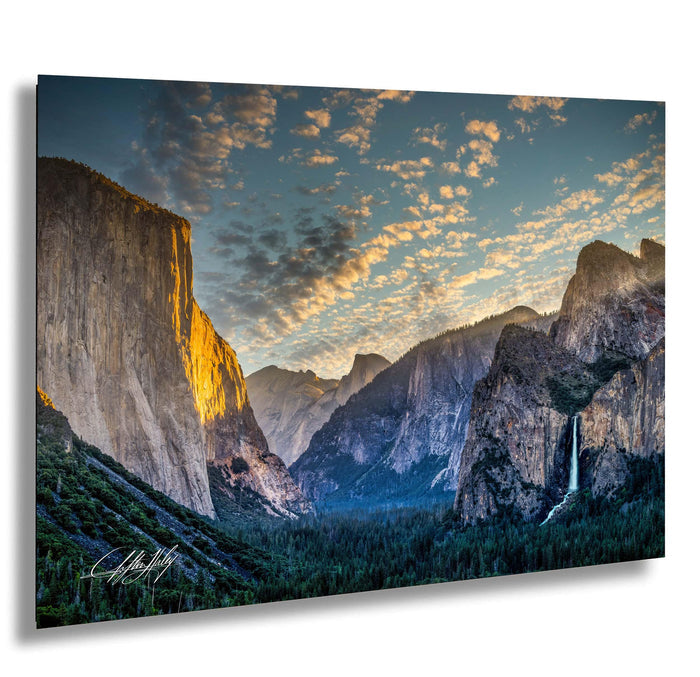 a breathtaking view of a mountainous landscape at sunset, with towering cliffs and a cascading waterfall.